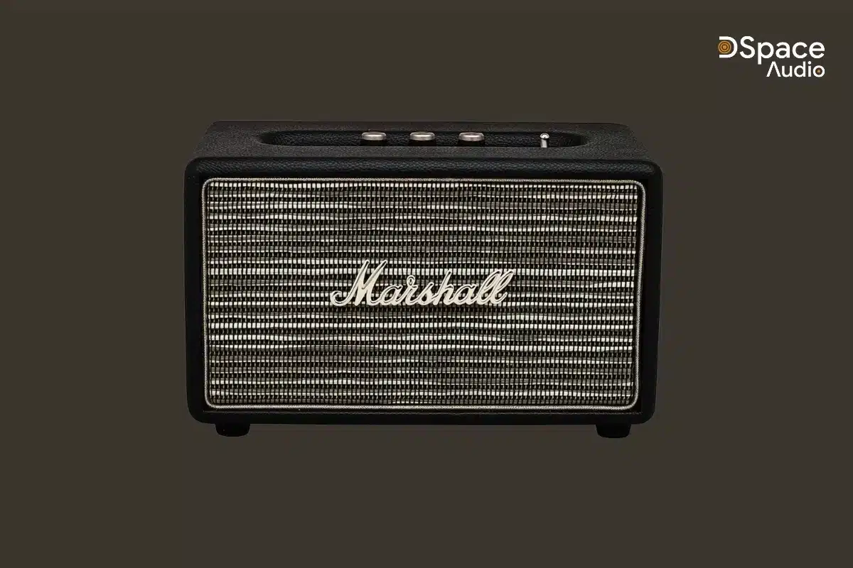 Marshall Acton sở hữu kiểu dáng hình hộp vuông vức, nhỏ gọn với kích thước 260 x 160 x 150 mm và trọng lượng chỉ 2,85kg. Vỏ ngoài được bọc da vinyl cao cấp, các góc bo tròn mềm mại, mặt trước là lưới kim loại chắc chắn in logo Marshall nổi bật – tất cả tạo nên một tổng thể vừa cổ điển, vừa sang trọng, đậm chất rock.